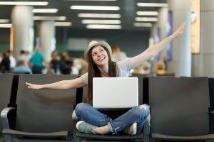 בחורה צעירה עם מחשב נייד בשדה התעופה